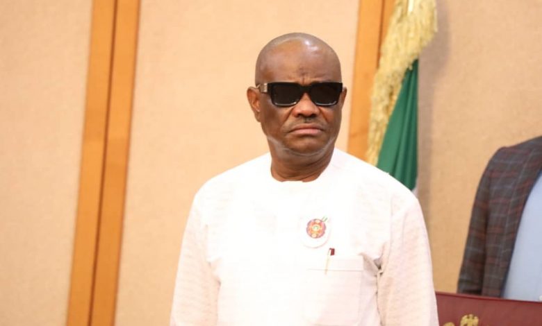 Governor Wike in a white attire and adorns a pair of sunglasses